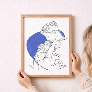Könnte beinhalten: Ein gerahmter Kunstdruck mit einer Schwarz-Weiß-Linienzeichnung eines Elternteils und eines Kindes. Ein blauer Kreis befindet sich hinter den Figuren. Die Worte "Dad & Luca" sind in Schreibschrift geschrieben. Der Rahmen besteht aus hellbraunem Holz.