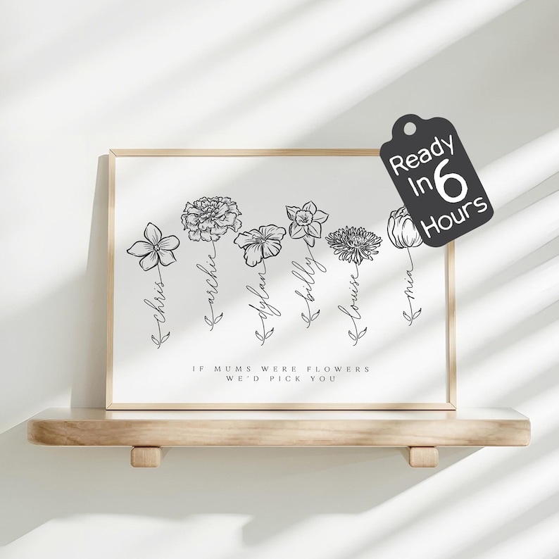 On a simple floating wooden shelf, a light wood–framed white family birth-flower line art print is lit by diagonal window shadows, featuring the header “The Miller family” and “SINCE 1993” above six labeled flower sketches, with a black tag-shaped sticker at the top right that says “Ready in 6 Hours.”