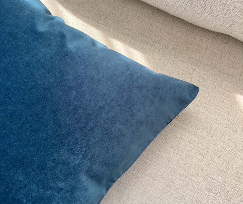 May include: A soft, blue velvet pillow cover. The cover is made of a plush, velvety fabric and has a smooth, even texture.