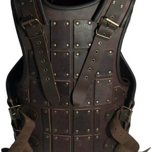May include: A brown leather armour vest with metal rivets and straps. The vest has a square pattern and is secured with buckles.