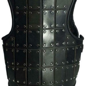 May include: Black leather vest with a grid pattern of square plates, each secured with silver rivets.