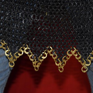 May include: Close-up of a black chainmail garment with a decorative gold-colored trim along the bottom edge. The chainmail is made of small, interlocking metal rings. The trim is made of gold-colored rings.