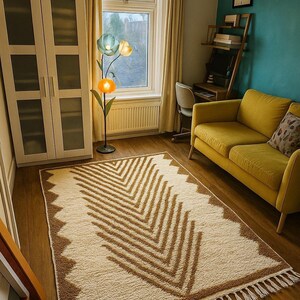 K&ouml;nnte beinhalten: Cremefarbener Teppich mit braunem geometrischen Muster und Fransen. Der Raum hat ein gelbes Sofa, eine blumenf&ouml;rmige Stehlampe und ein Fenster mit gelben Vorh&auml;ngen. Der Raum hat Holzb&ouml;den und eine t&uuml;rkisfarbene Wand.