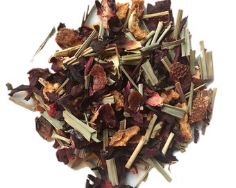 May include: A close-up of a blend of dried fruit, herbs, and flowers for making herbal tea. The mix includes red hibiscus flowers, orange peel, lemongrass, and other ingredients.