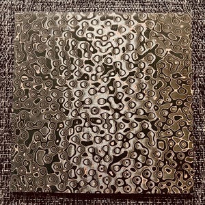 May include: A close-up of a black and white patterned surface with a swirling, abstract design. The pattern resembles a series of interconnected circles and ovals.