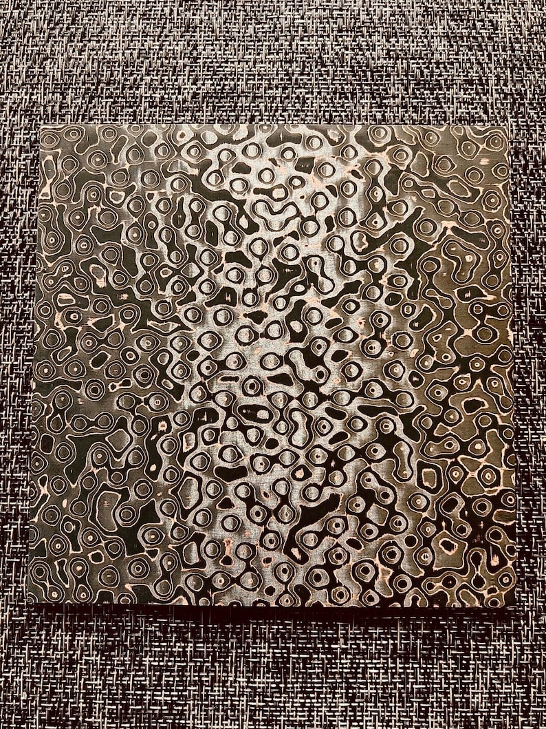 May include: A close-up of a black and white patterned surface with a swirling, abstract design. The pattern resembles a series of interconnected circles and ovals.