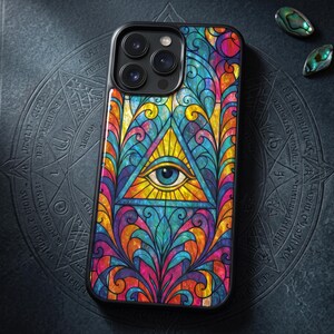 Könnte beinhalten: Eine Smartphone-Hülle mit einem lebendigen, mehrfarbigen Buntglas-Muster. Das Design zeigt ein zentrales gelbes Dreieck mit einem detaillierten blauen Auge, umgeben von komplizierten, geschwungenen Blumenmotiven in Rot-, Blau- und Orangetönen.