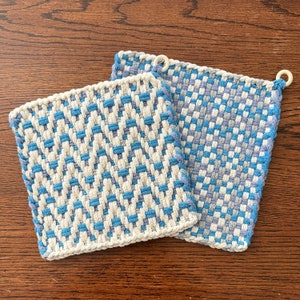 May include: Two woven pot holders in a blue and white checkered pattern. One pot holder has a diagonal pattern and the other has a horizontal pattern.