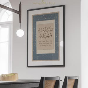 May include: A black framed print with a blue background and white stars. The print features Arabic calligraphy and the text "My Lord Open my heart, and make my task easy for me".