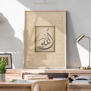 Pu&ograve; includere: Una stampa incorniciata con uno sfondo beige e una cornice dorata. La stampa presenta un design di calligrafia in bianco e nero della parola araba "Allah" in un quadrato con un bordo dorato. La stampa &egrave; appesa a un muro sopra una scrivania con una lampada, libri e una pianta in vaso.