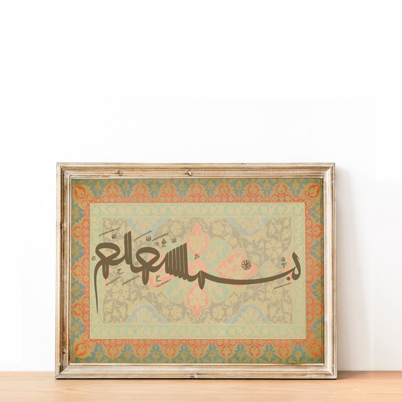 May include: A framed print with an intricate floral design in shades of blue, green, and orange. The print features a calligraphic inscription in brown ink, "Assalamu alaykum", against a beige background.
