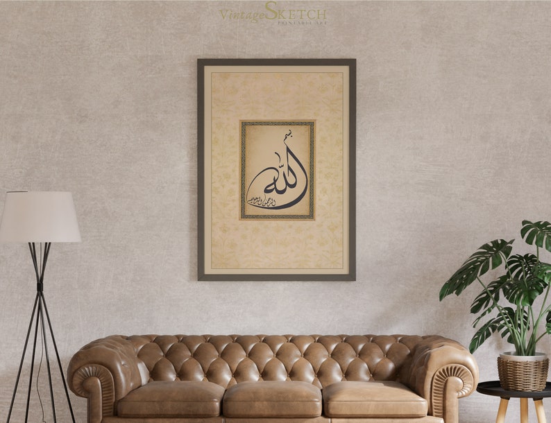 Pu&ograve; includere: Una stampa incorniciata con uno sfondo beige e un design di calligrafia nera della parola "Allah" in una cornice dorata. La stampa &egrave; appesa a un muro con un divano in pelle marrone e una pianta in vaso in primo piano.