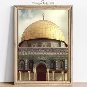May include: A framed print of a photograph of the Dome of the Rock in Jerusalem. The dome is gold and the building is decorated with intricate tile work.