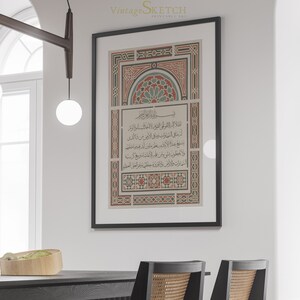 May include: A black framed print with a white background and intricate red, green, and blue geometric patterns. The print features Arabic calligraphy in black.