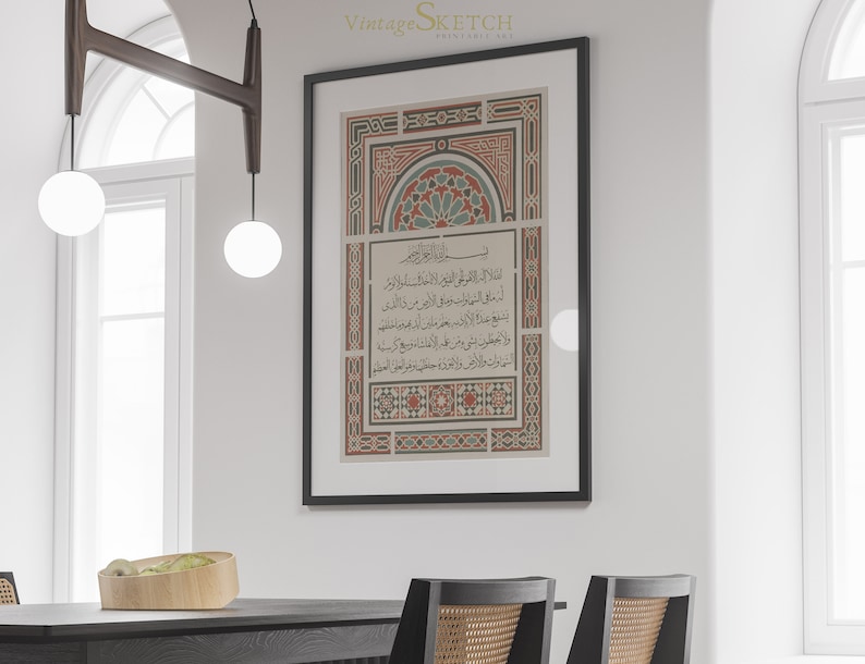 May include: A black framed print with a white background and intricate red, green, and blue geometric patterns. The print features Arabic calligraphy in black.