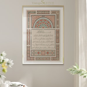 May include: A framed print with a gold frame and a decorative border. The print features Arabic calligraphy in black and white with a red and green geometric pattern in the background. The text reads "المثلا إله الأموالي القيوم لا الخلاية والأقوم الر ما في السماوات وما في الأرضين من ذالذي ولا مع كرسية".