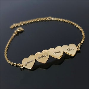 Puede incluir: Pulsera de cadena dorada con cuatro dijes en forma de corazón, cada uno grabado con un nombre: Jasmin, Michael, Anna y Chris.