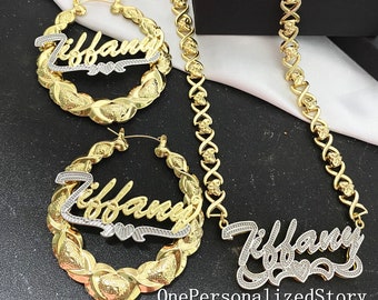 May include: Gold and silver tone nameplate necklace and hoop earrings with the name "Tiffany" on them. The necklace is a thick, gold chain with a box clasp. The earrings are large and have a rope-like design.