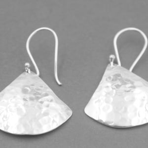 May include: A pair of silver hammered teardrop earrings with a textured finish.