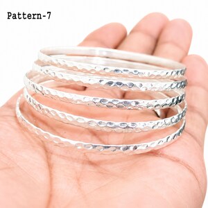 Sterling silver bangle stack worn as an everyday bracelet set, demonstrating the layered look and fixed round fit.