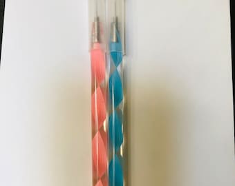 Peut inclure: Deux outils de quilling avec des corps en plastique transparent et des motifs en spirale. L'un est rose, l'autre bleu. Chacun a une pointe argentée et un capuchon transparent. Outils pour travaux manuels.