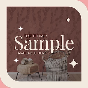 May include: A sample of wallpaper with a cactus pattern is displayed in a room setting. The text "TEST IT FIRST! Sample AVAILABLE HERE" is overlaid on the image. A woven chair and side table are also shown.