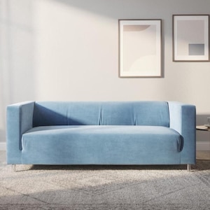 以下が含まれることがあります： 長方形の形をした、明るい青色のモダンなソファ。 ソファはロープロファイルで、シルバーの脚の上にあります。 部屋は、パターン化されたラグと、壁に2つの額入りの抽象芸術作品を備えたニュートラルなカラーパレットが特徴です。