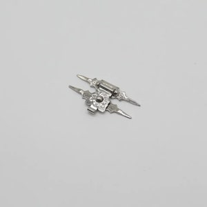 May include: A silver-toned metal hinge featuring an elongated, pointed design with decorative floral-inspired detailing at the center. The hardware has a central pivot point and symmetrical, sharp-edged wings extending from the middle hinge mechanism.