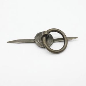 May include: Antique bronze-toned drawer pull with a circular handle and a decorative rosette. The pull has a long, pointed base, and the ring handle is attached to the rosette. The hardware is made of metal and is designed for furniture.