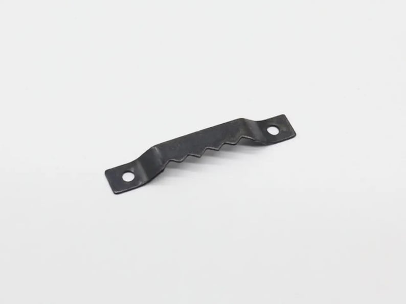 May include: Black metal picture hanging hook with two holes and a serrated edge.