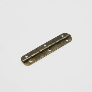May include: A brass-colored hinge with a series of small, round pins connecting the two plates. The hinge is designed for attaching two surfaces together, allowing them to fold or open.