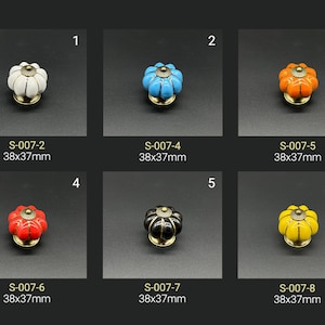 May include: Six different colored ceramic cabinet knobs with a pumpkin shape and gold accents. Each knob measures 38 mm by 37 mm.