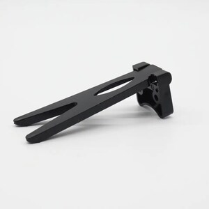 May include: A black, angled support bracket with a forked base and a slotted design. The bracket has a rectangular end with several circular openings. The object is made of a matte black material and is set against a white background.