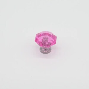 Op de afbeelding: Roze kristallen kastknop met een facetgeslepen ontwerp en een zilveren basis.