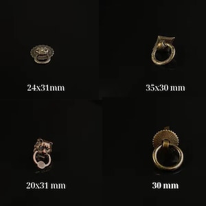 May include: Four antique brass drawer pulls in various designs. The pulls include a lion's head, a ring pull, and a decorative sunburst design. Measurements are provided in millimeters: 24x31mm, 35x30 mm, 20x31 mm, and 30 mm.