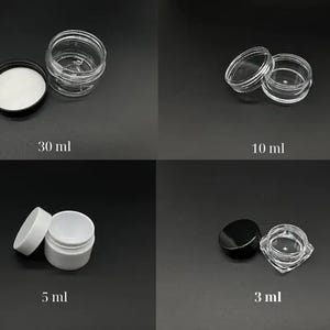 May include: Four small cosmetic jars of varying sizes are displayed against a dark background. The jars are labelled with their capacity: 30 ml, 10 ml, 5 ml, and 3 ml. The jars are clear or white with black or white lids.