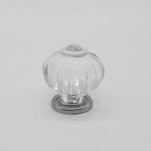 May include: Clear glass cabinet knob with a fluted design and a silver base.