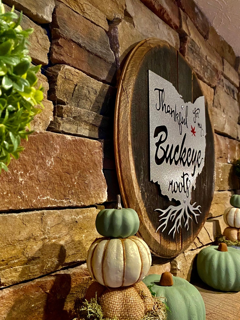 Ohio State Buckeye painted metal sign attached to Authentic Bourbon Barrel Head