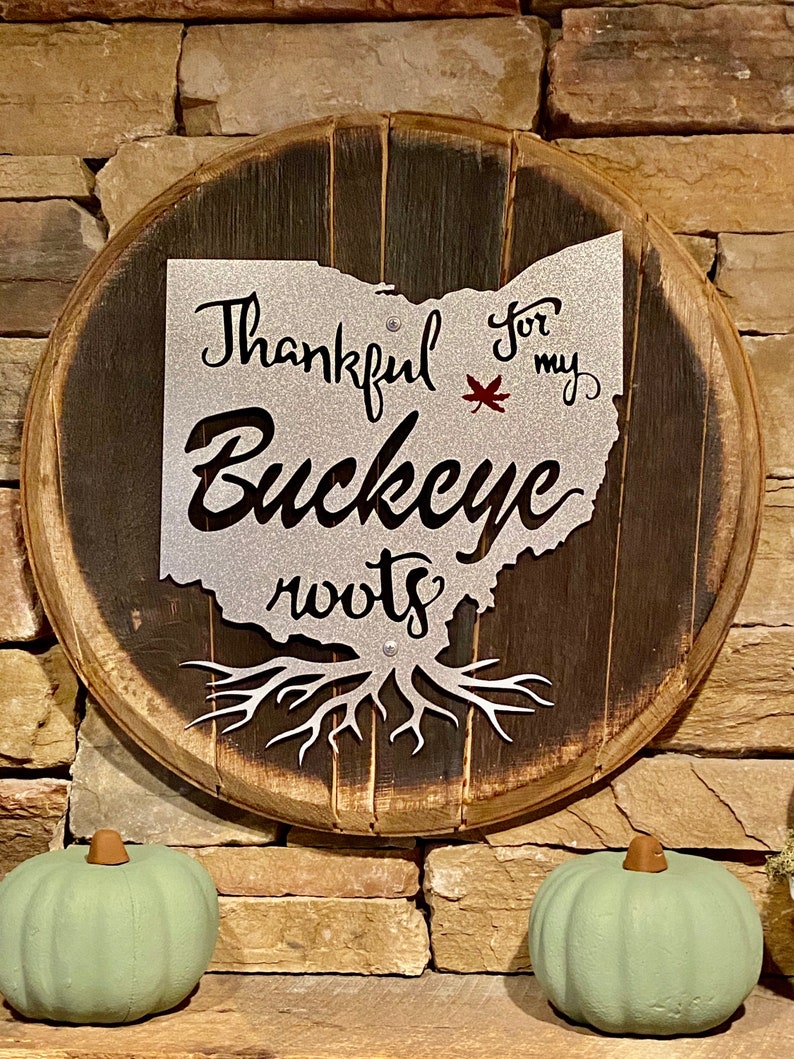 Ohio State Buckeye painted metal sign attached to Authentic Bourbon Barrel Head