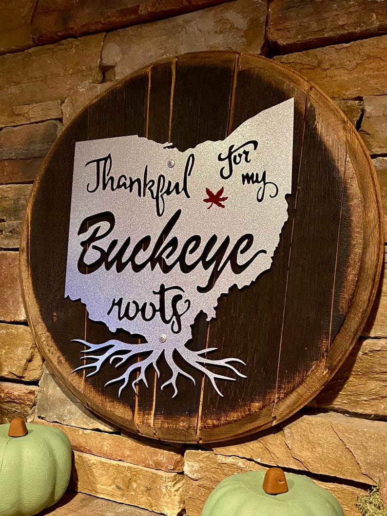 Ohio State Buckeye painted metal sign attached to Authentic Bourbon Barrel Head