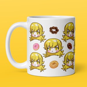 May include: White ceramic mug with a yellow cartoon character with different facial expressions and donuts and pastries printed on it.