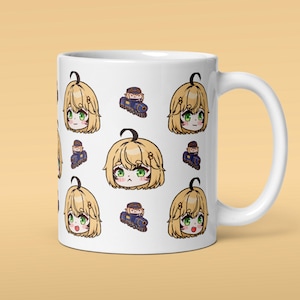 May include: White ceramic mug featuring a repeating pattern of anime-style character faces with blonde hair and green eyes, and small blue trains. The mug has a large, curved handle.