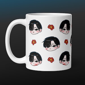May include: White ceramic mug featuring a repeating pattern of cartoon faces with black hair and red flower accents. The faces have a variety of expressions. The mug has a large, curved handle.