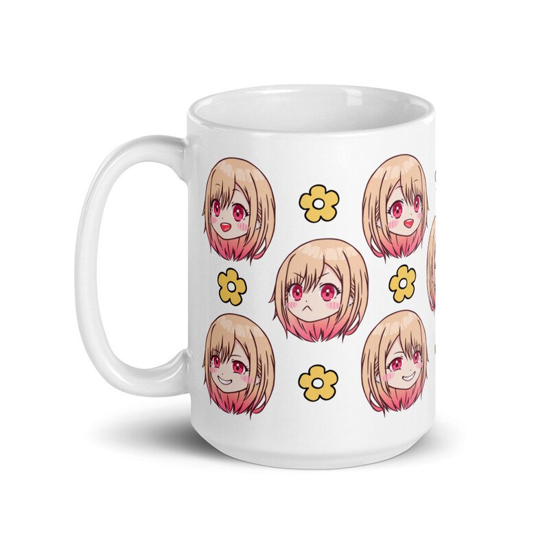 May include: White ceramic mug featuring a repeating pattern of a cartoon girl with blonde hair and pink cheeks. The girl has different facial expressions. Each girl is surrounded by yellow flowers.