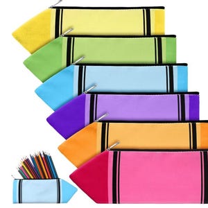 Puede incluir: Un conjunto de seis estuches con forma de crayón en amarillo, verde claro, azul claro, morado, naranja y rosa, cada uno con cremallera plateada y rayas negras. Un estuche más pequeño de color azul claro contiene lápices de colores.