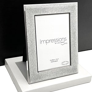 May include: Silver glitter photo frame with a white mount and the text "Impressions by Juliana" and "13x18cm | 5x7" photo frame.