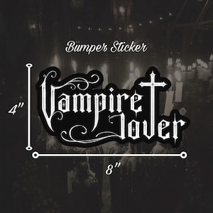 May include: Black bumper sticker with the words "Vampire Lover" in a gothic font, with a cross incorporated into the letter "T". The sticker is 8 inches wide and 4 inches tall.