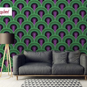 Puede incluir: Un patrón de papel tapiz geométrico verde oscuro y morado con un diseño repetitivo de arcos superpuestos. El papel tapiz se muestra en un ambiente de sala de estar con un sofá gris y una mesa auxiliar de madera.