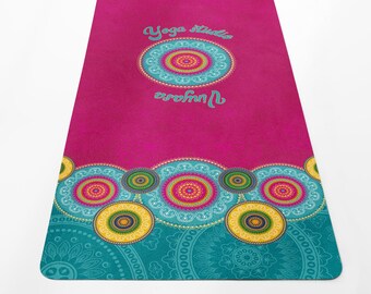 May include: A pink yoga mat with a teal and gold mandala design. The text "Yoga studio universe" is printed in white on the mat.