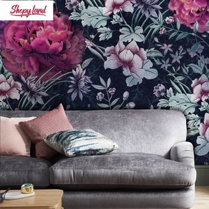 May include: A gray velvet sofa with three pillows, a wooden coffee table, and a rug. The sofa is in front of a wall with a floral wallpaper featuring pink and white flowers on a dark blue background. The text "Shopy Land" is visible in the top left corner of the image.